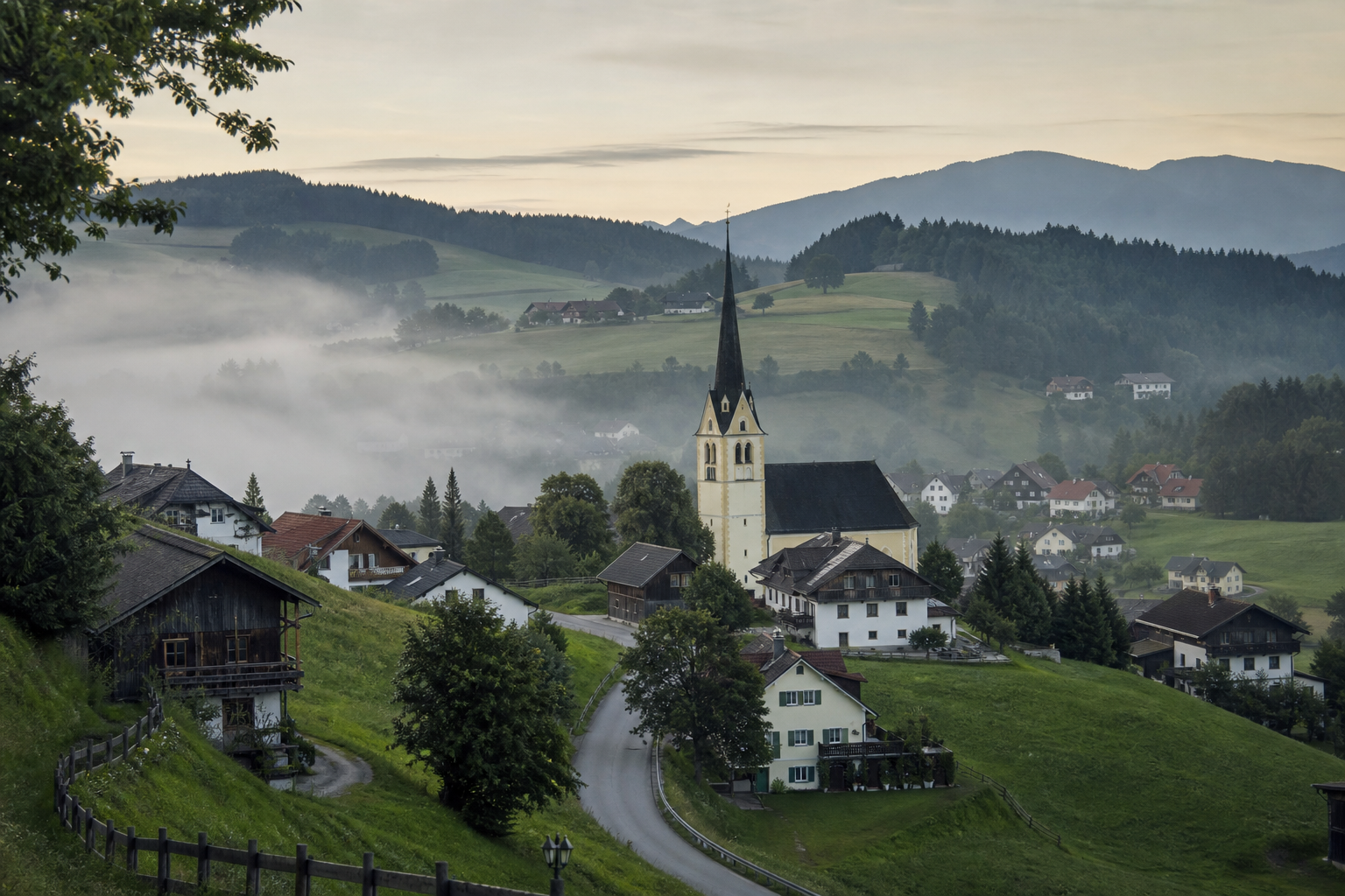 Kleines deutsches Dorf zwischen grünen Hügeln